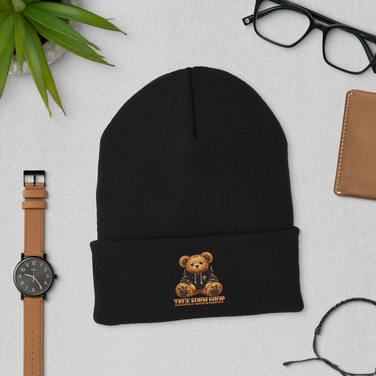 Black True Form premium hypoallergenic cuffed acrylic beanie with a teddy bear in a hoodie and True Form Shop lettering on the cuff.